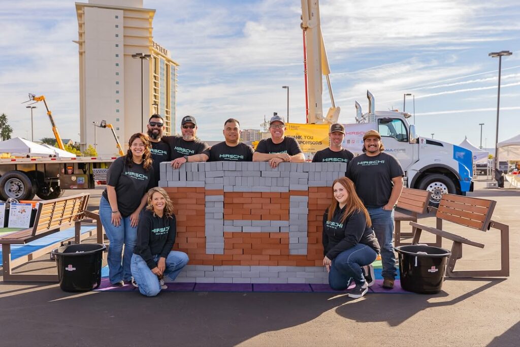 Hirschi helping hands team standing in front of bricks that spell out an H in Las Vegas Nevada